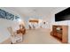 Bright living room with carpeted floors, large window, and adjacent kitchen at 21226 Royal St Georges Ln, Leesburg, FL 34748
