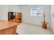 Home office with neutral walls, carpeted floors, a window providing natural light, and wood desk and shelves at 21226 Royal St Georges Ln, Leesburg, FL 34748