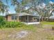 Beautiful backyard featuring mature trees, a screened-in porch and a well-maintained lawn at 2216 River Ridge Rd, Deland, FL 32720