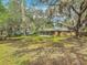 The expansive backyard featuring lush greenery and mature trees with a screened-in porch on the home at 2216 River Ridge Rd, Deland, FL 32720