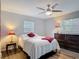 Cozy bedroom features a ceiling fan, two windows, and wood laminate flooring at 2216 River Ridge Rd, Deland, FL 32720