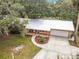 Charming single-story brick home featuring a metal roof, covered front porch, and well-manicured lawn with circular driveway at 2216 River Ridge Rd, Deland, FL 32720