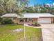 Charming brick home with a metal roof, an attached garage, and a well-manicured front lawn at 2216 River Ridge Rd, Deland, FL 32720