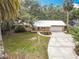 Charming brick home with a metal roof, attached garage, landscaped yard, and a welcoming driveway at 2216 River Ridge Rd, Deland, FL 32720