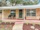 Inviting front porch with chairs, brick details, and lush landscaping, creating a cozy entrance at 2216 River Ridge Rd, Deland, FL 32720