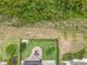 Aerial view of the backyard featuring brick patio, firepit, seating and lush lawn of the property with fenced perimeter at 224 Silver Maple Rd, Groveland, FL 34736