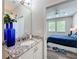 Bathroom with granite countertop, blue vases and bedroom view with a large queen bed at 224 Silver Maple Rd, Groveland, FL 34736