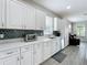 Modern kitchen featuring white cabinets, stylish backsplash, and stainless steel appliances at 224 Silver Maple Rd, Groveland, FL 34736