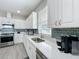 Modern kitchen with stainless steel appliances, white cabinetry, and ample counter space at 224 Silver Maple Rd, Groveland, FL 34736