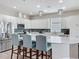 Well-lit kitchen features white cabinets, stainless steel appliances, modern backsplash, and a counter with barstool seating at 224 Silver Maple Rd, Groveland, FL 34736