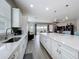 Open kitchen featuring white cabinets, granite counters, stainless sink, and seamless access to the living area at 224 Silver Maple Rd, Groveland, FL 34736