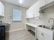 Bright laundry room with sink, desk, storage cabinets, and modern washer and dryer at 224 Silver Maple Rd, Groveland, FL 34736