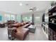 Sunlit living room with sliding glass doors, an entertainment center, and a piano, offering serene views at 224 Silver Maple Rd, Groveland, FL 34736