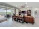 Cozy living room features a leather sofa, modern console table, wood-look floors, and views of the backyard patio at 224 Silver Maple Rd, Groveland, FL 34736