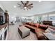Expansive living room showcases a ceiling fan, kitchen, sitting area and wood-look tile flooring throughout at 224 Silver Maple Rd, Groveland, FL 34736