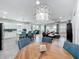 Open-concept living space with modern chandelier, island seating, and hardwood dining table at 224 Silver Maple Rd, Groveland, FL 34736