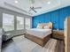 Main bedroom features a striking blue accent wall, a ceiling fan, and large windows for natural light at 224 Silver Maple Rd, Groveland, FL 34736