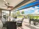 Covered patio with brick floor and lake view, featuring a ceiling fan and stylish furniture at 224 Silver Maple Rd, Groveland, FL 34736
