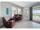 Sitting room with a piano, leather armchair, and large windows overlooking the outdoor patio at 224 Silver Maple Rd, Groveland, FL 34736