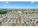 Expansive aerial view of a well-maintained neighborhood with lush landscaping and a serene lake at 2457 Upton St, The Villages, FL 32163