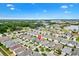 Wide aerial perspective showcasing a community surrounded by green spaces and a tranquil lake at 2457 Upton St, The Villages, FL 32163