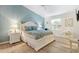 Cozy bedroom featuring a queen-sized bed, soothing blue walls, and natural light at 2457 Upton St, The Villages, FL 32163
