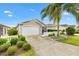 Charming single-story home with a front yard, a driveway, and a attached two-car garage at 2457 Upton St, The Villages, FL 32163