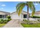 Inviting home exterior with a well-manicured lawn, pretty landscaping, and a white picket fence at 2457 Upton St, The Villages, FL 32163