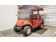 Golf cart parked inside the garage with epoxy flooring and ample storage, perfect for recreational vehicles and accessories at 2457 Upton St, The Villages, FL 32163
