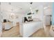 Open kitchen with white cabinetry, stainless appliances, breakfast bar, and wood-look flooring at 2457 Upton St, The Villages, FL 32163