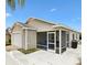 Back of single-story home featuring a screened-in patio and a concrete patio, ideal for outdoor living at 2457 Upton St, The Villages, FL 32163