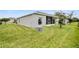 Spacious backyard with well-maintained lawn, exterior view of the home, and lush landscaping at 27215 White Plains Way, Leesburg, FL 34748