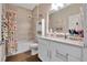 Well-lit bathroom with white cabinets, a shower-tub combo, and stylish decor at 27215 White Plains Way, Leesburg, FL 34748