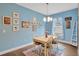 Bright dining room with wooden table, chairs, rug, blue accent wall, and Disney decor at 27215 White Plains Way, Leesburg, FL 34748