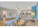 Bright living room featuring a blue accent wall, hardwood floors, comfortable furniture, and an open layout into the kitchen at 27215 White Plains Way, Leesburg, FL 34748
