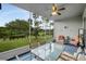 Covered and screened patio with comfortable seating and a beautiful view of the manicured lawn at 27215 White Plains Way, Leesburg, FL 34748