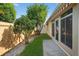 Well maintained backyard featuring a cement walkway, green grass, and several leafy trees at 2744 Gresham Ave, The Villages, FL 32162