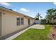 Exterior shot of home with concrete patio, striped awning and lush green grass at 2744 Gresham Ave, The Villages, FL 32162