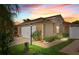 Attractive single-story home with a two-car garage, manicured lawn, and colorful sunset sky at 2744 Gresham Ave, The Villages, FL 32162