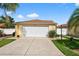 Well-maintained home featuring a two-car garage, manicured lawn, and neat landscaping at 2744 Gresham Ave, The Villages, FL 32162
