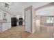 Modern kitchen featuring white cabinetry, black appliances, and an open view to living spaces at 2744 Gresham Ave, The Villages, FL 32162