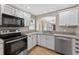 Bright kitchen with white cabinets, granite countertops, stainless steel appliances, and a view to the dining area at 2744 Gresham Ave, The Villages, FL 32162