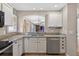 Kitchen featuring white cabinets, granite countertops, stainless steel appliances and a cutout looking into the dining area at 2744 Gresham Ave, The Villages, FL 32162