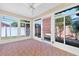 Enclosed sunroom featuring brick floors, light walls, and multiple windows to the exterior at 2744 Gresham Ave, The Villages, FL 32162