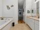 Bright bathroom featuring a soaking tub, tile floors, and a dual sink vanity at 3001 Lake Huron Ln, Tavares, FL 32778