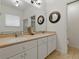 Bright bathroom featuring a dual sink vanity, neutral countertops, and decorative wall mirrors at 3001 Lake Huron Ln, Tavares, FL 32778