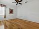 Bedroom with wood floors, ceiling fan, window and art at 3001 Lake Huron Ln, Tavares, FL 32778