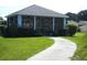 Inviting screened cabana, embraced by verdant landscaping, providing a tranquil retreat for relaxation and outdoor enjoyment at 3001 Lake Huron Ln, Tavares, FL 32778