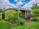 Home exterior with a screened-in patio and lush landscaping featuring flowers and manicured grass at 3001 Lake Huron Ln, Tavares, FL 32778