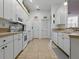 Full kitchen view featuring white appliances and cabinetry with tiled flooring at 3001 Lake Huron Ln, Tavares, FL 32778